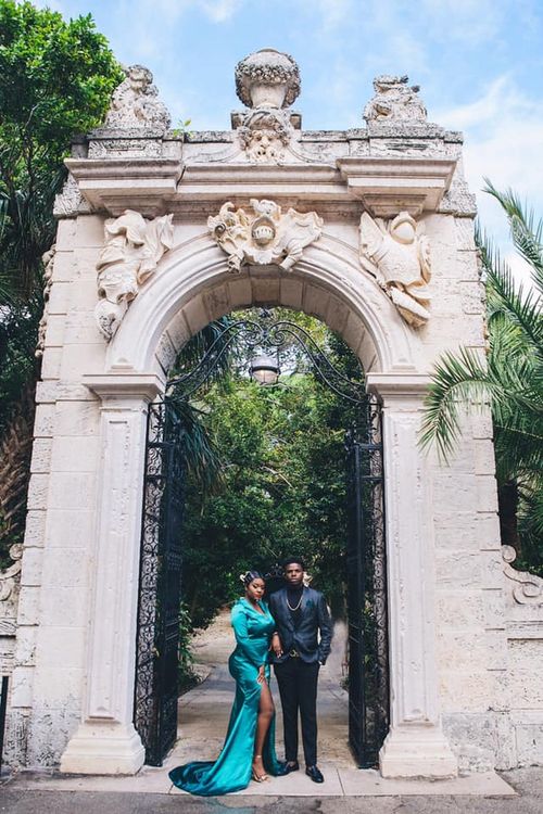 Couple framed by a grand carved stone archway