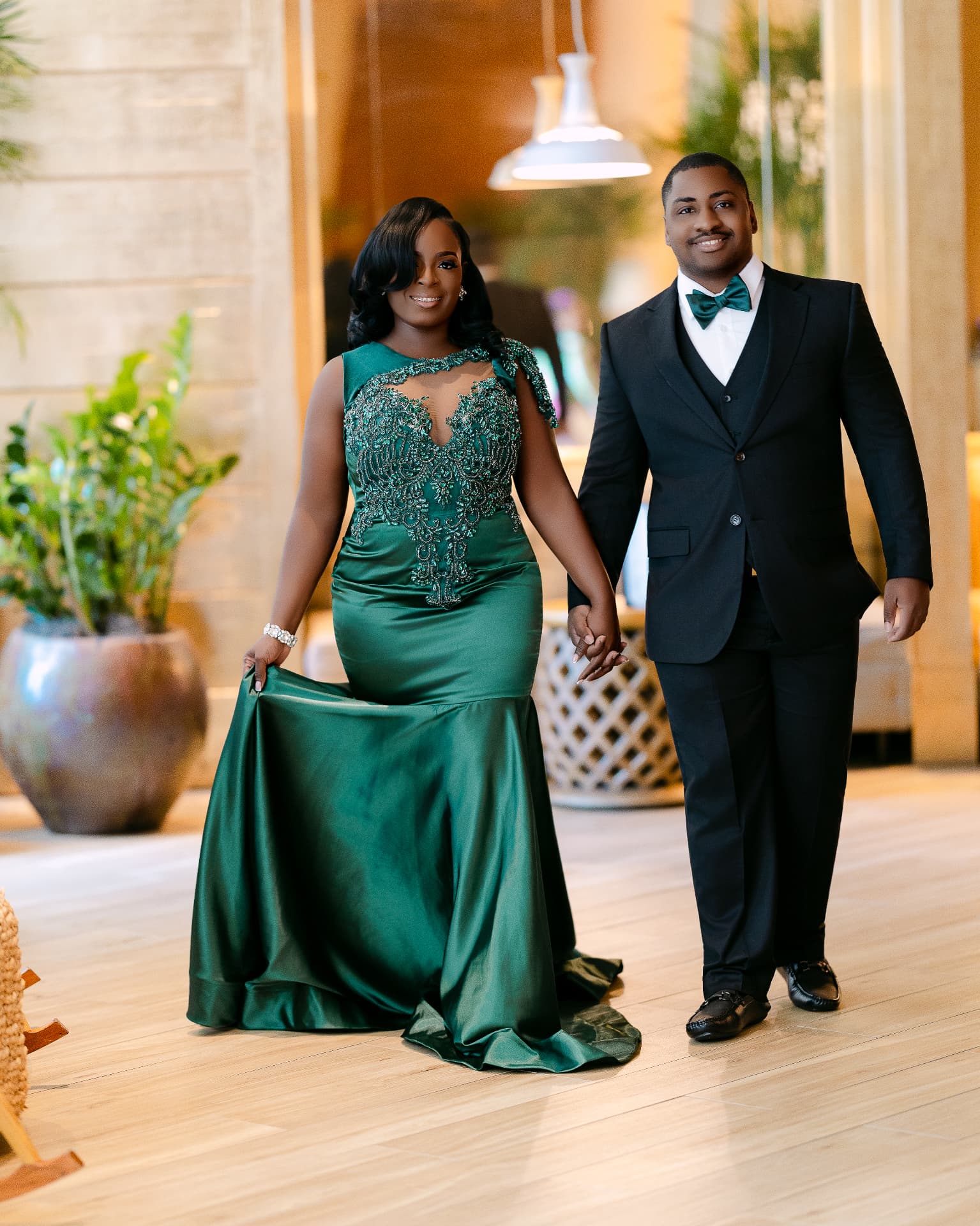 Couple walking hand in hand in emerald green and black tie