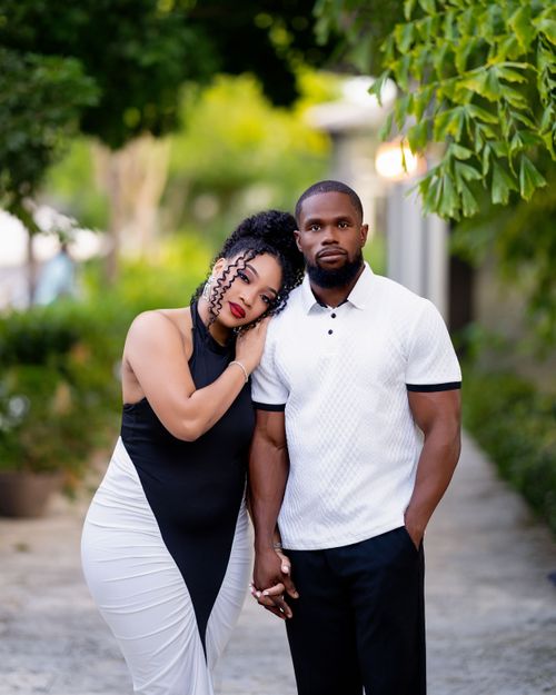 Couple in black and white attire on a garden pathway