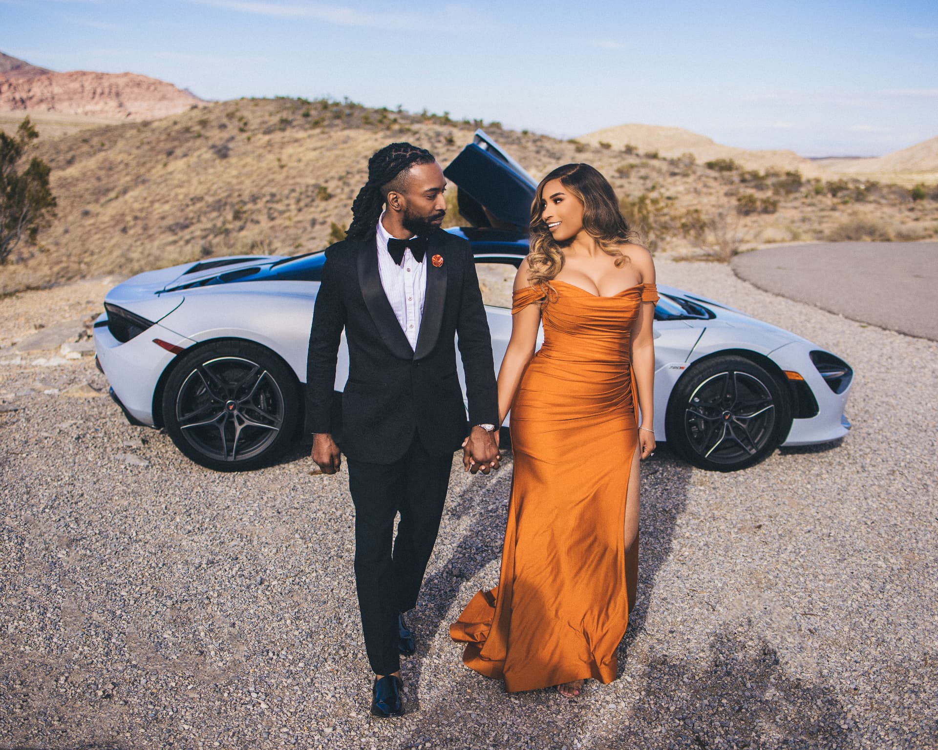 Couple walking hand in hand through the desert at golden hour