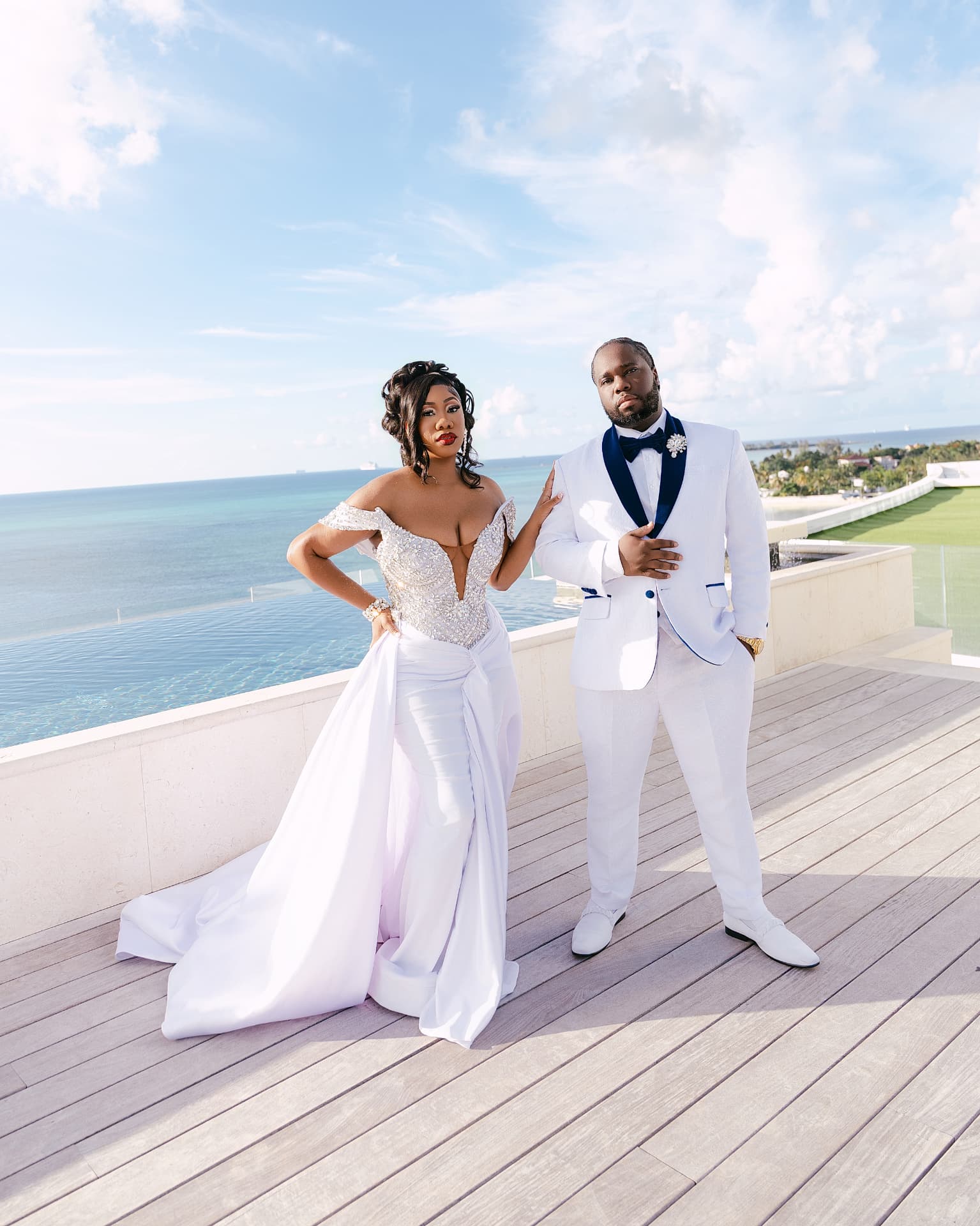 Couple posing on a rooftop deck overlooking turquoise water