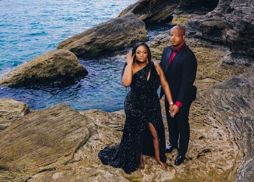 Couple on rocky coastline, bride in black sequin gown