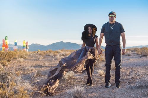 Couple in the desert at golden hour, gown flowing in the wind