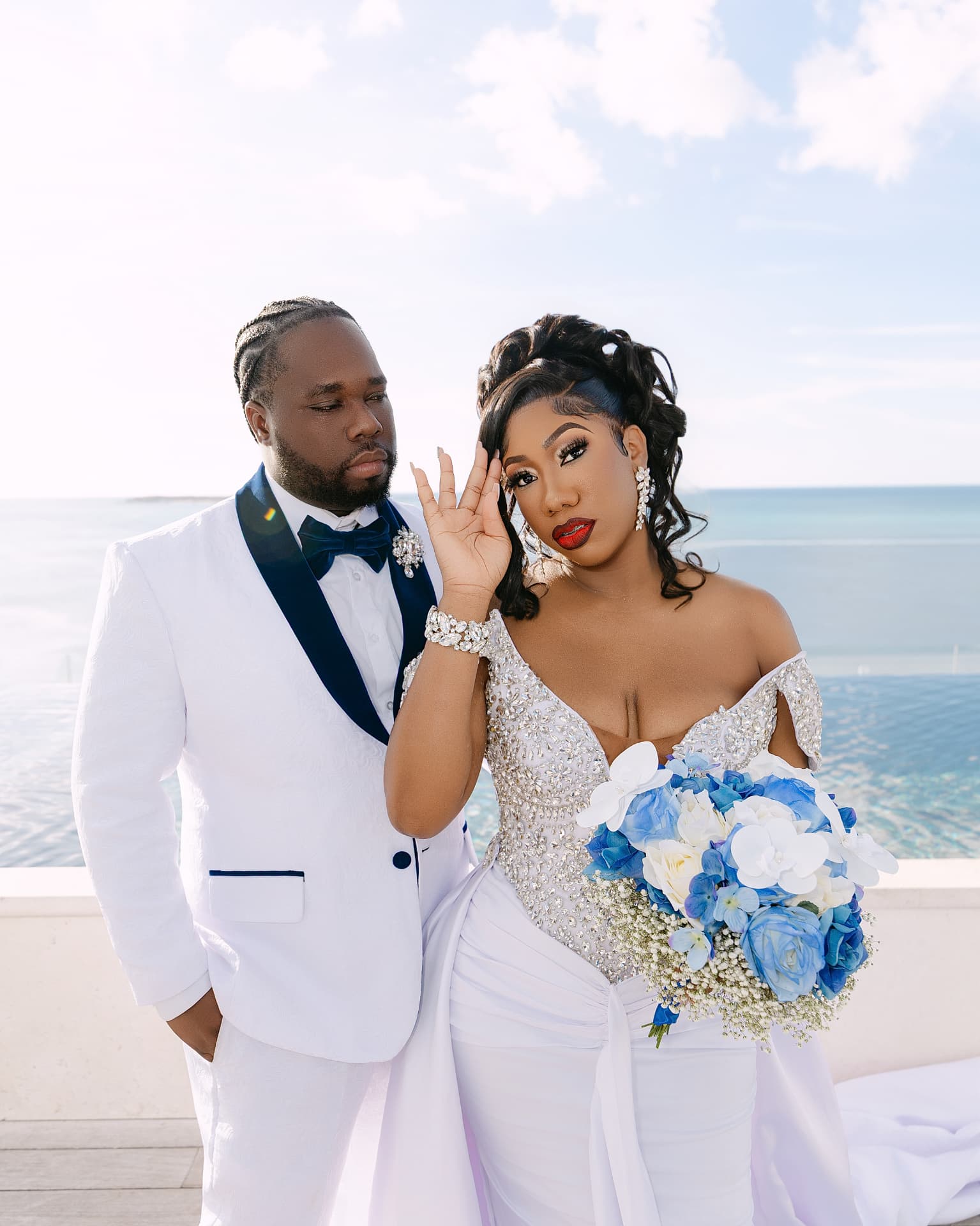 Close portrait of a bride with a blue bouquet beside her groom