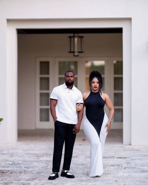 Couple standing before a white archway entrance