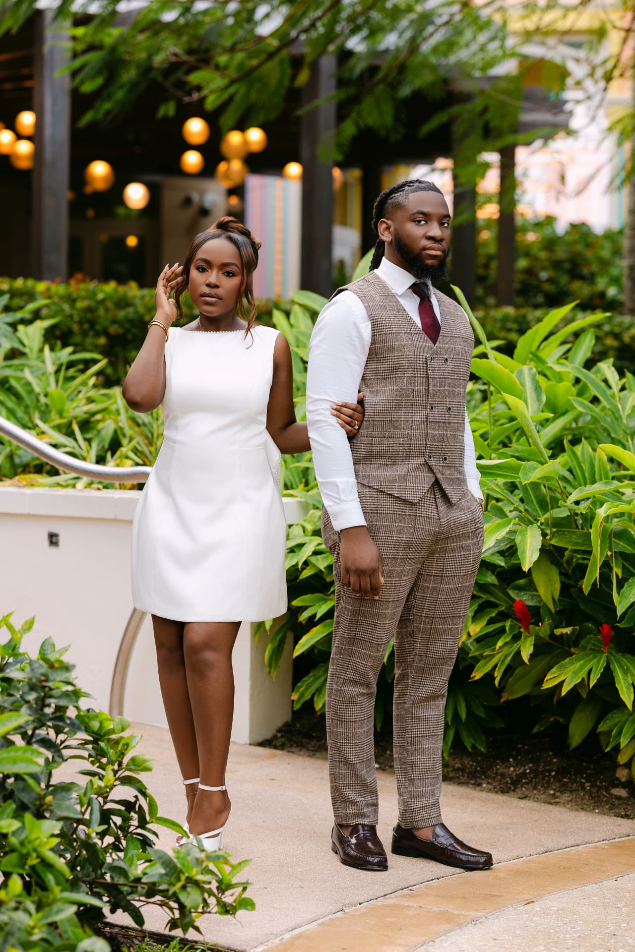 Couple posing back to back among tropical greenery