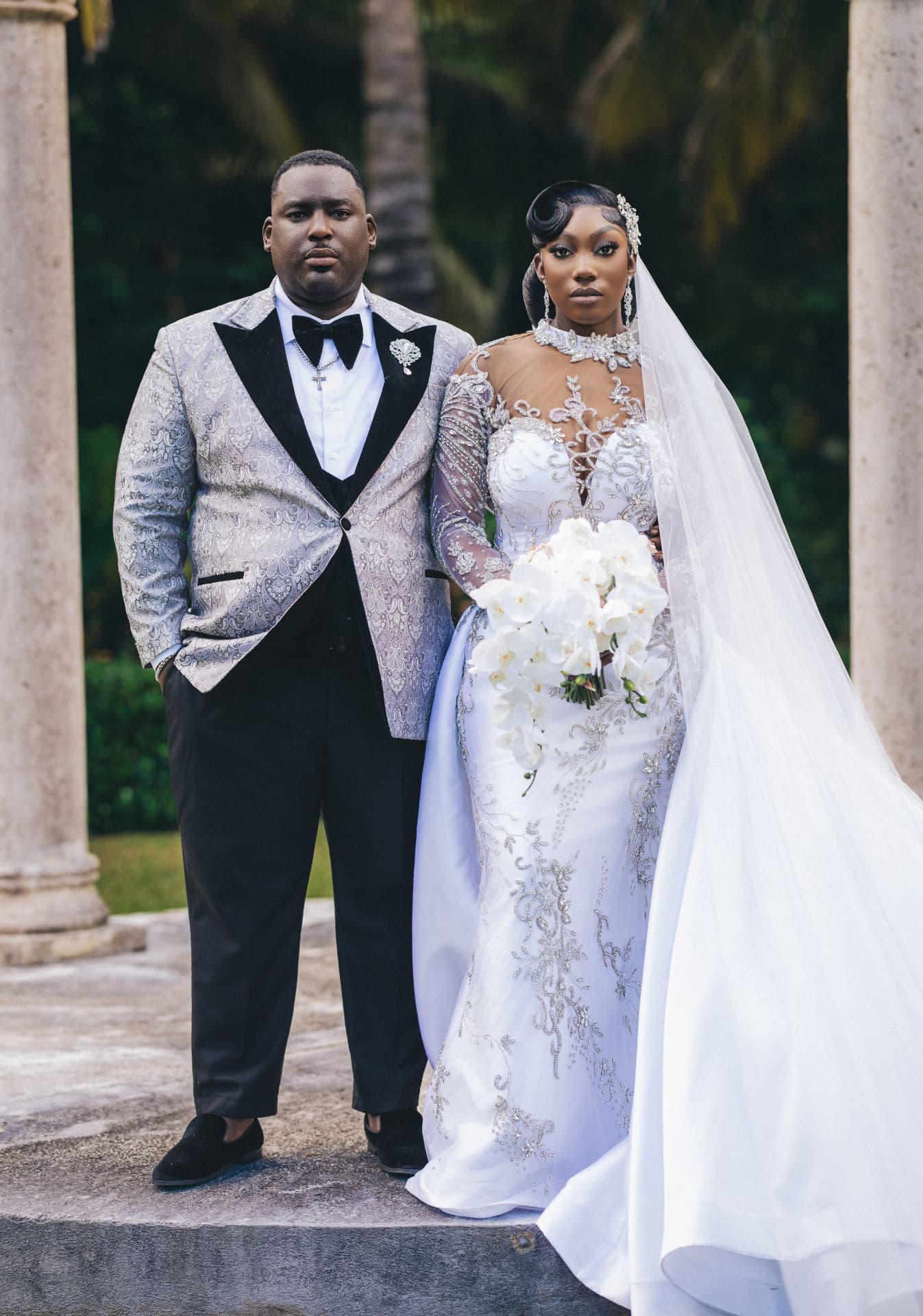Newlyweds walking hand in hand down a candlelit corridor